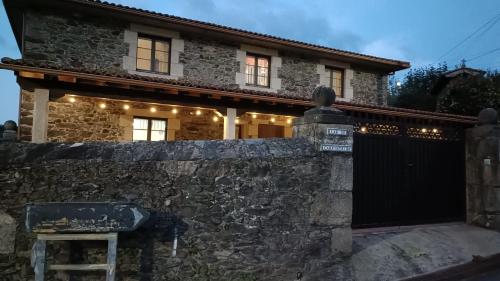 a stone house with a gate and a stone wall at Casa Rural Oza dos Ríos in Oza dos Ríos