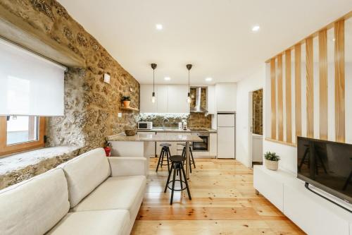 a living room with a couch and a kitchen at Casa do Castelo in Covilhã