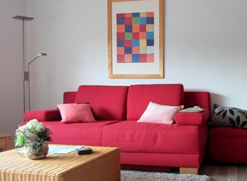 a red couch in a living room with a table at Appartement Maya in Winterberg