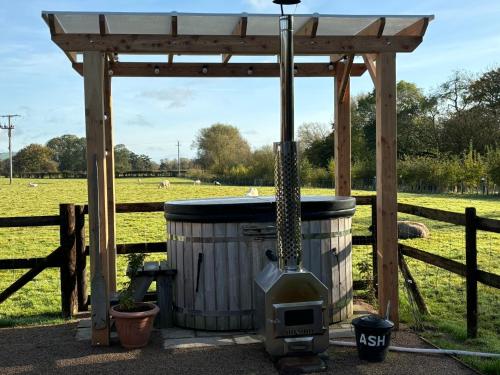 a gazebo with a hot tub next to a field at Bron Hafren in Montgomery