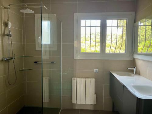 une salle de bain avec une douche en verre et un lavabo dans l'établissement FASLAM 1455, aux Issambres