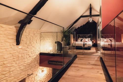 Cette chambre comprend 2 lits et une paroi en verre. dans l'établissement Volute et Volupté - Une Spirale de Plaisirs, à Hiéville