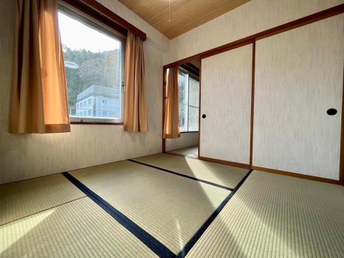 an empty room with a large window and a floor at Yuzawa house 2 - Vacation STAY 39933v in Yuzawa