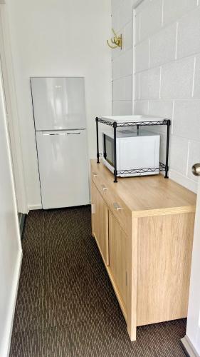a kitchen with a refrigerator and a wooden counter at House of Somer in Matamata
