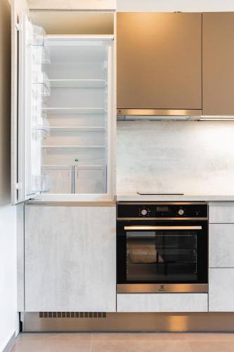 a kitchen with an empty refrigerator and an oven at Lion PARKK Apartments in Kníničky