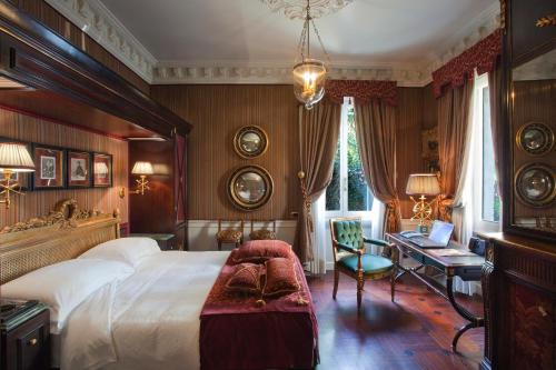 a bedroom with a large bed and a desk at Hotel de la Ville Monza - Small Luxury Hotels of the World in Monza