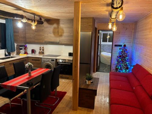 a living room with a red couch and a christmas tree at SOFROS VALLEY HILLS CHALET in Ayios Mamas