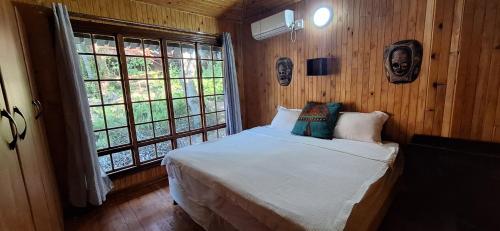 a bedroom with a bed in a room with wooden walls at Casa Bella Ntsuty 21 in Ponta do Ouro