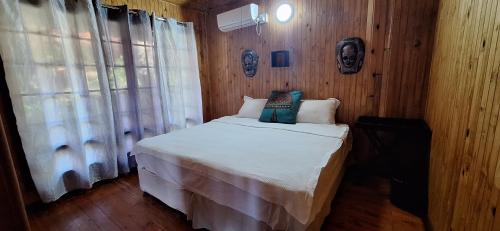 a bedroom with a bed in a wooden wall at Casa Bella Ntsuty 21 in Ponta do Ouro