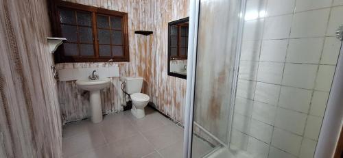 a bathroom with a toilet and a sink and a shower at Casa Bella Ntsuty 21 in Ponta do Ouro