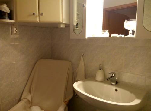 a bathroom with a toilet and a sink at DebreCenter Apartman in Debrecen