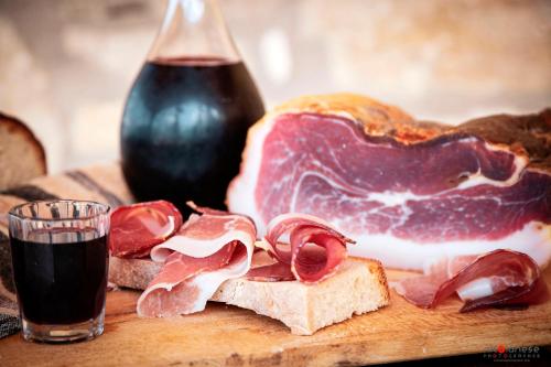 a piece of bread with meat and a glass of wine at Agriturismo Terra e Sapori in Campodipietra
