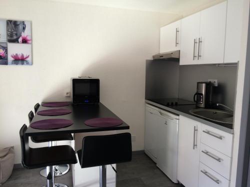 - une cuisine avec une table et un ordinateur portable dans l'établissement Joli studio rénové au cœur du village de St Lary, à Saint-Lary-Soulan