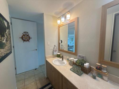 a bathroom with a sink and a mirror at Ocean & Marina Views 3 Bedroom 2 Bathroom Luxury Condo in Fajardo