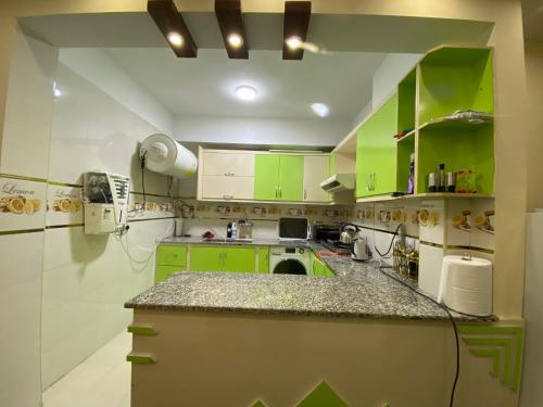 a kitchen with green cabinets and a counter top at Cityscape luxury residence in Kabul
