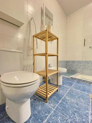 a bathroom with a white toilet and a sink at Centric Rooms Madera Gran Via in Madrid