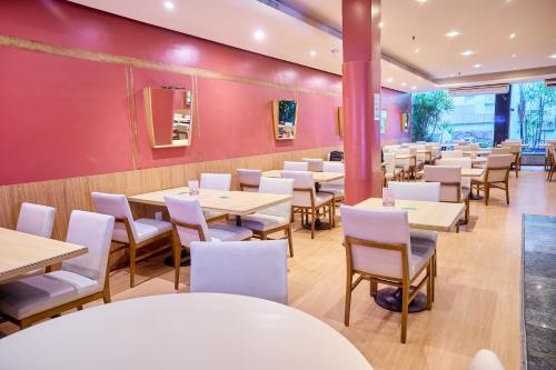 a restaurant with tables and chairs and red walls at South American Copacabana Hotel in Rio de Janeiro