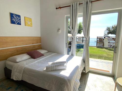 a bedroom with a bed and a large window at Casa playa Puerto Luz, Alquiler vacacional in Santa Marta