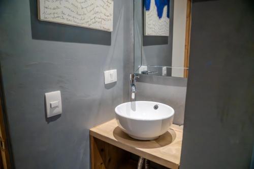 a bathroom with a white bowl sink on a counter at Hotel Boutique Aldea del Mar in Pichilemu