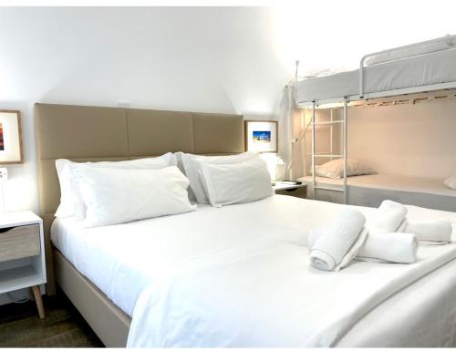 a large white bed with white pillows on it at Vila Alexandra in Costa da Caparica