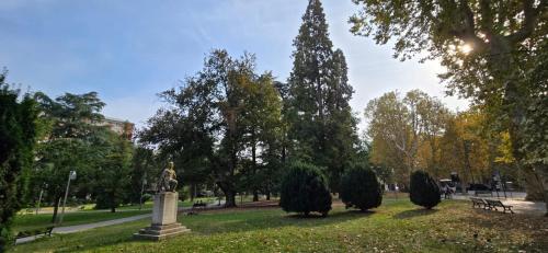 a park with a statue in the grass and trees at Jungle Sunshine Apartment in Alessandria
