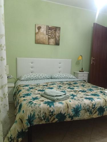 a bedroom with a bed with a comforter on it at B&B Kazakova in Domusnovas