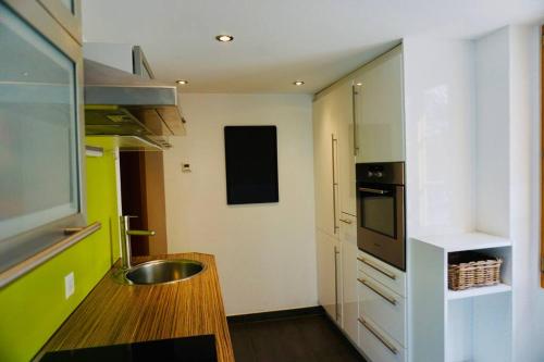 una cocina con fregadero y encimera en Central Local Flat, en Zermatt