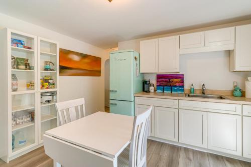 a kitchen with white cabinets and a blue refrigerator at 5 Mi to Vero Beach Vintage Home with Sauna and Grill! in Vero Beach