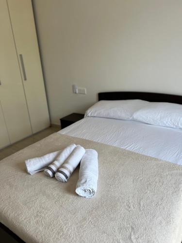 two rolled towels sitting on top of two beds at Magical modern apartment in Victoria