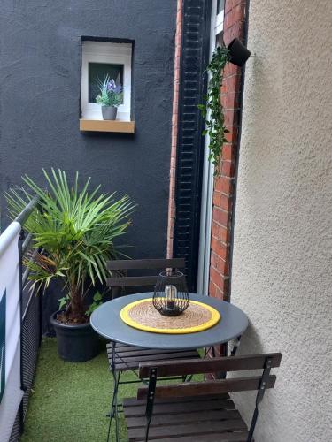 a table and a bench on a patio with plants at Les Loges Du Théatre 160m2 PRIVÉ 14 personnes MAX tout équipé a 200m de l'AVENUE DE CHAMPAGNE et toutes commodités DEGUSTATION CHAMPAGNE OFFERTE jacuzzi sauna jeux velos EMPLACEMENT EXCEPTIONNEL et CHIC in Épernay