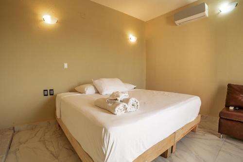 a bedroom with a bed with towels on it at Guitarra Inn in Puerto Escondido
