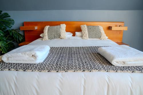 a bed with white sheets and pillows on it at Hotel Boutique Aldea del Mar in Pichilemu