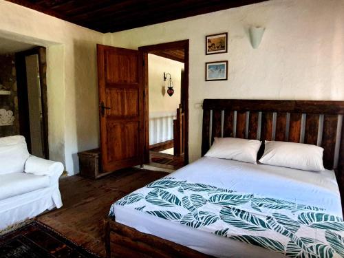 a bedroom with a bed with a wooden headboard at Stone house in Faralya in Fethiye