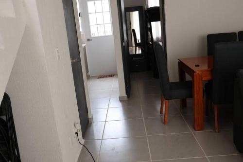 a hallway with a table and a chair and a door at casa con club de playa in General Juan N Alvarez International Airport