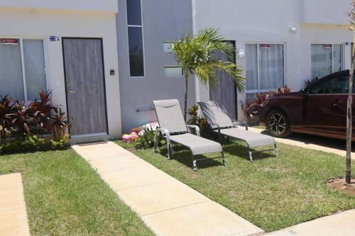 two chairs and a car parked in front of a house at casa con club de playa in General Juan N Alvarez International Airport