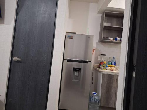 a small kitchen with a refrigerator in a room at casa con club de playa in General Juan N Alvarez International Airport