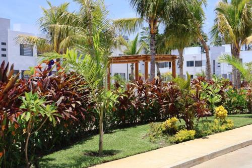 a garden with palm trees and a wooden structure at casa con club de playa in General Juan N Alvarez International Airport