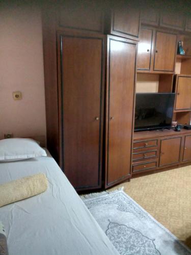 Un dormitorio con una cama y un televisor y armarios. en Магнолия, en Elkhovo