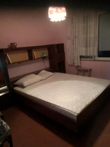 Un dormitorio con una cama grande con cabecero de madera. en Магнолия, en Elkhovo
