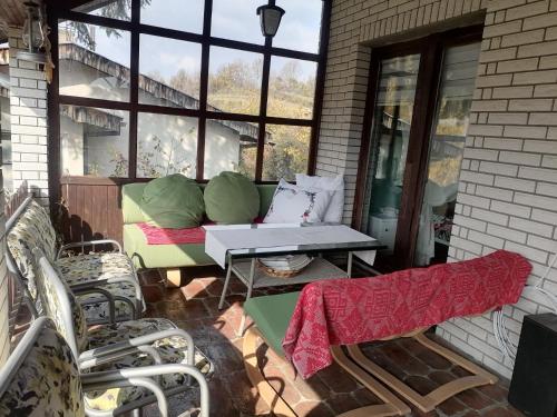 a patio with a couch and a table and chairs at Vila Seoska idila in Izvor