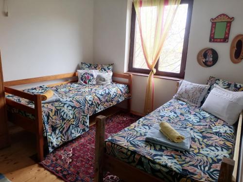 a bedroom with two beds and a bed and a window at Vila Seoska idila in Izvor