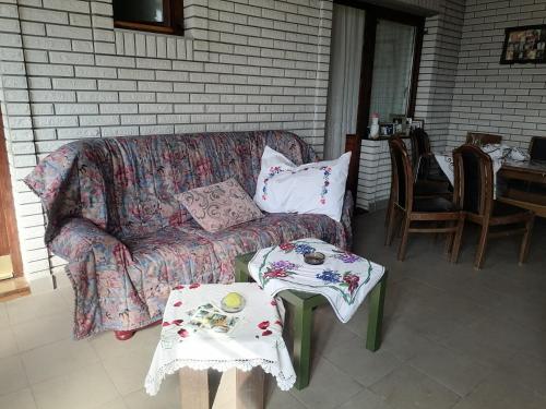 a couch and two tables on a patio at Vila Seoska idila in Izvor