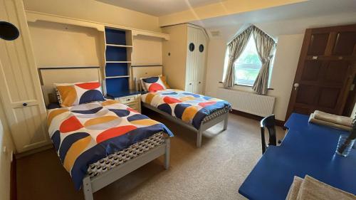 Un dormitorio con dos camas y una ventana. en Scartagh House, Scartagh, Clonakilty, en Clonakilty