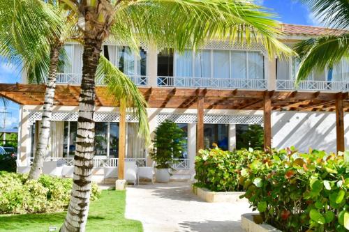 a building with palm trees in front of it at Beach Day at CadaquesCaribe Bayahibe in Bayahibe