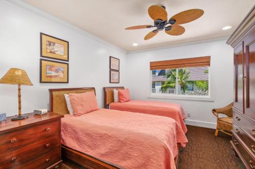 a bedroom with two beds and a ceiling fan at Luxury Poipu 4br Villa with AC Walk to the Beach! (224) in Koloa