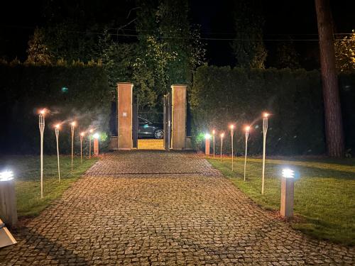 a cobblestone street with street lights at night at Stately Home in Magdalenka Warsaw in Magdalenka
