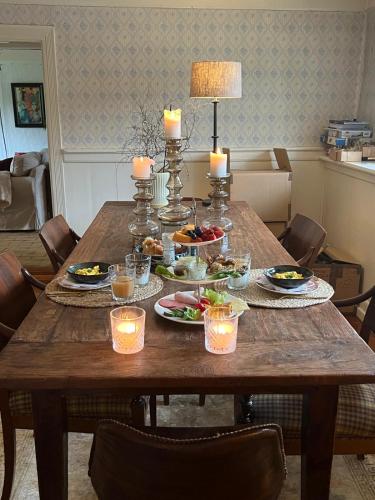 a wooden table with food and candles on it at Solbjerggaard Bed & Breakfast in Fåborg