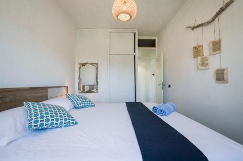 a bedroom with a large white bed with blue pillows at Vila Vera Seafront Apartments in Sumartin