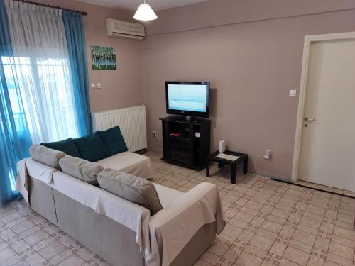 a living room with a couch and a flat screen tv at Σαν Στο Σπίτι Σας in Xanthi