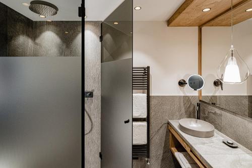 a bathroom with a shower and a sink at Lake Spa Hotel SEELEITEN in Caldaro